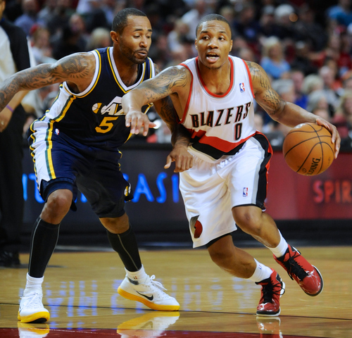Utah Jazz' Mo Williams (5) defends a drive by Portland Trail Blazers' Damian Lillard (0) during the second half of an NBA preseason basketball game in Portland, Ore., Monday, Oct., 22, 2012. Lillard had 21 points as the Trail Blazers beat the Jazz 120-114. (AP Photo/Greg Wahl-Stephens)