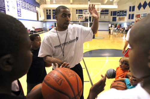 Rick Egan   |  The Salt Lake Tribune

Johnnie Bryant works with kids, during a dribbling drill, during an open house for his life skills academy, Saturday, June 5, 2010.