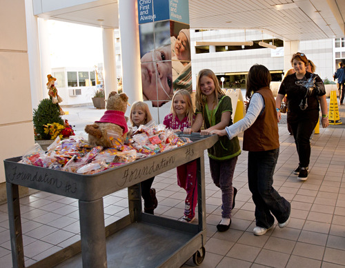 Lennie Mahler  |  The Salt Lake Tribune
Kassie Aupperle and other Girl Scouts  wheel in a cart full of candy to children at Primary Children's Medical Center on Tuesday, Oct. 30, 2012. Following complications and multiple hospitalizations from a hearing aid implant earlier this year, Kassie had the idea to deliver candy to hospitalized kids who wouldn't be able to Trick-or-Treat on Halloween. Cassie organized her Girl Scout troop, 2382, and troop 2385 to deliver over 300 candy packs to the hospital.