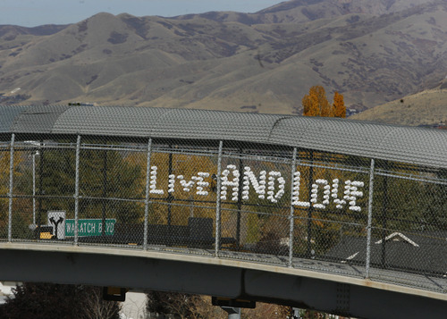 Scott Sommerdorf  |  The Salt Lake Tribune              
Cups in the chain link fence of the Oakview Drive overcrossing over Wasatch Blvd spell out "LIVE AND LOVE" as car and bike traffic pass beneath, Sunday, November 4, 2012.