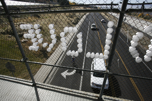 Scott Sommerdorf  |  The Salt Lake Tribune              
Cups in the chain link fence of the Oakview Drive overcrossing over Wasatch Blvd spell out "LIVE AND LOVE" as car and bike traffic pass beneath, Sunday, November 4, 2012.