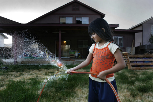 Scott Sommerdorf  |  The Salt Lake Tribune             
Deisi Gonzalez's daughter Kelsey, 4, plays with the water hose in the backyard of their home in Reno. They will most likely lose the home in a short sale, and move into an apartment. They stopped regularly watering the grass when Deisi stopped making payments.