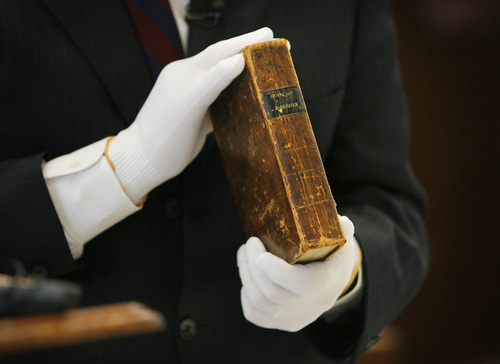 Tribune file photo
In this 2009 photo, the gloved hands of Church Historian Marlin Jensen hold a first-edition of The Book of Mormon once owned by James H. Moyle in 1906.