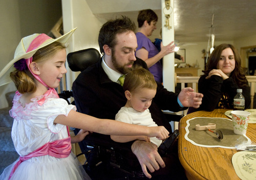 Kim Raff  |  The Salt Lake Tribune
Rich McKenzie lets his niece and nephew play with his wheelchair as his new wife, Amy McKenzie, looks on at their home in Plain City, Utah, on October 28, 2012. Rich McKenzie was with his four friends on a trip at the San Rafael Swell in celebration of their high school graduation when he dove into a river with a hidden sandbar just below the surface. He became instantly paralyzed. Fourteen years later, the five have stayed friends, all getting married and starting families except for Rich -- until now. He met Amy Terry last year and they were married last month.