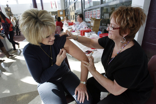 Francisco Kjolseth  |  The Salt Lake Tribune
Laurie Anderson, a secretary at Lone Peak High School in Highland, takes advantage of the flu shots being administered in the school on Tuesday, November 6, 2012, as licensed practical nurse Tyra Hazen prepares her arm. Public health officials say the best way to prevent getting influenza this flu season is to get your annual flu shot. Utah County kicked off its community clinics, offered at sites around the county.