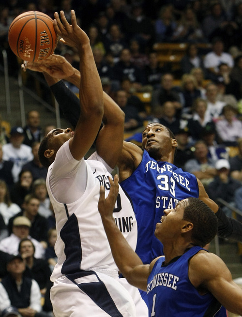 Chris Detrick  |  The Salt Lake Tribune
Brigham Young Cougars forward Brandon Davies (0) is fouled by Tennessee State Tigers forward Robert Covington (33) and Tennessee State Tigers forward Kellen Thornton (1) during the second half of the game at the  Marriott Center Friday November 9, 2012.  BYU won the game 81-66.