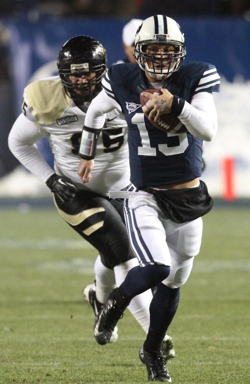 Rick Egan  | The Salt Lake Tribune 

Brigham Young Cougars quarterback Riley Nelson (13) is chased by Idaho Vandals defensive tackle Ryan Edwards (95) as he runs for a first down on a quarterback keeper, in football action, BYU vs. Idaho Vandals, at Lavell Edwards Stadium, Saturday, November 10, 2012