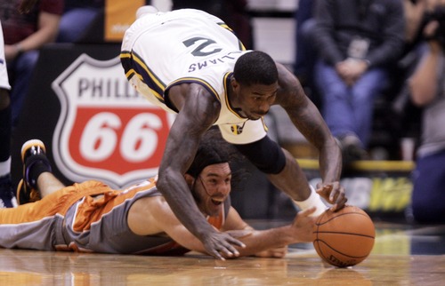 Kim Raff  |  The Salt Lake Tribune
Utah Jazz power forward Marvin Williams (2) dives over Phoenix Suns power forward Luis Scola (14) for a loose ball during the second half at EnergySolutions Arena in Salt Lake City, Utah on November 10, 2012. The Jazz went on to win the game 94-81.
