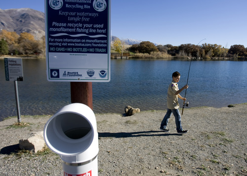 Kim Raff | The Salt Lake Tribune
While carrying his fishing poll Zachary Bumgardner, from troop 8 Lehi, walks past a newly installed monofilament fishing line recycler at Highland Glen Park in Highland, Utah on October 29, 2012.  Bumgardner is part of the troop that  John and Steven Peterson belong to and made it their Eagle Scout project to install these container a few locations near fishing areas and do outreach about the dangers monofilament fishing line pose to wildlife.