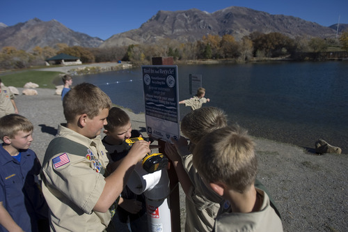 Kim Raff | The Salt Lake Tribune
(right) Eagle Scouts Steven Petersen and (second on left) John Petersen with the help of members of their Boy Scout troop put up a container they helped to build to recycle monofilament fishing line at the pond at Highland Glen Park in Highland, Utah on October 29, 2012. The two boys decided to do outreach about the dangers of monofilament fishing line to wildlife as their Eagle Scout project and have been able to install these container a few locations near fishing areas.