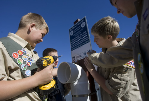 Kim Raff | The Salt Lake Tribune
(right) Eagle Scouts Steven Petersen and (left) John Petersen with the help of members of their troop put up a container they helped to build to recycle monofilament fishing line at the pond at Highland Glen Park in Highland, Utah on October 29, 2012. The two boys decided to do outreach about the dangers of monofilament fishing line to wildlife as their Eagle Scout project and have been able to install these container a few locations near fishing areas.