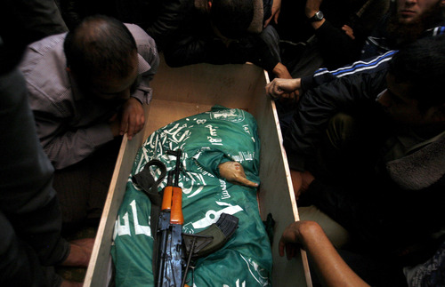 Palestinian mourners gather around the body of Hamas member Mohammad Al Hams during his funeral in Gaza City, Thursday, Nov. 15, 2012. Israel barraged the Gaza Strip with airstrikes and shelling Wednesday and killed the Hamas military chief in a targeted strike, launching a campaign aimed at stopping rocket attacks from Islamic militants. The assault killed 10 other Palestinians, including two children and seven militants. On Thursday, militant rockets fired into Israel killed three Israelis, raising the likelihood of a further escalation.(AP Photo/Hatem Moussa)