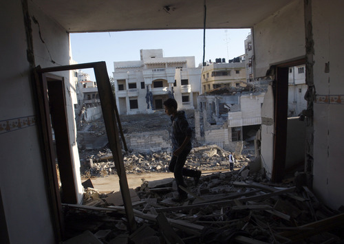 A Palestinian youth walks through a damaged apartment hit in an Israeli strike, in Gaza City ,Thursday, Nov. 15, 2012. Israeli aircraft, tanks and naval gunboats pounded the Hamas-ruled Gaza Strip and rocket salvoes thudded into southern Israel, as residents on both sides of the frontier holed up at home in anticipation of heavy fighting on the second day of Israel's offensive against Islamic militants. (AP Photo/Hatem Moussa)