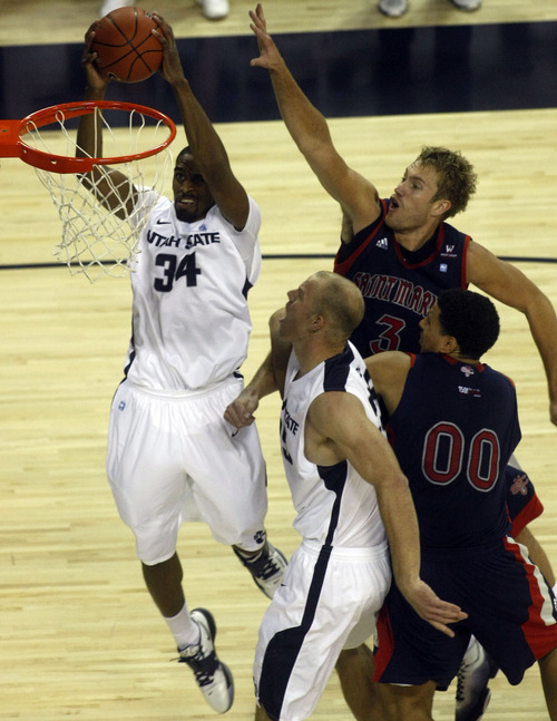 Chris Detrick  |  The Salt Lake Tribune
Utah State Aggies forward Kyisean Reed (34) dunks the ball past St. Mary's Gaels forward Mitchell Young (3) and St. Mary's Gaels forward Brad Waldow (0) during the first half of the game at Dee Glen Smith Spectrum Thursday November 15, 2012. St. Mary's is winning the game 34-31.