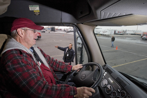 Paul Fraughton  |   Salt Lake Tribune
Lance Williamson, of Eugene Oregon listens to his instructor Brian Lillie who shouts out directions as Williamson  backs his big rig  between orange cones, at  CR England's  truck driving range.
 Friday, November 16, 2012