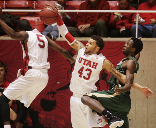 Kim Raff  |  The Salt Lake Tribune
University of Utah player (middle) Cedric Martin grabs a rebound over and Sacramento State player John Dickson during a men's basketball game at the Huntsman Center in Salt Lake City on November 16, 2012. They went on to lose the game 71-74.