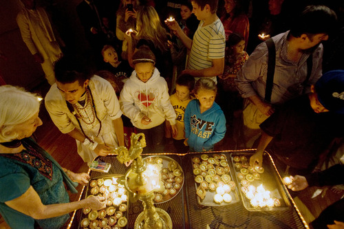 Kim Raff  |  The Salt Lake Tribune
People pick up lamps to place down in front of Gods Rama and Sita while making a wish during the Diwali, the festival of lights, celebration for the Indian New Year at the Krishna Temple in Salt Lake City on November 18, 2012.