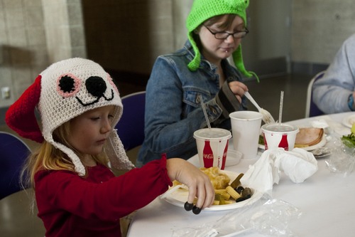 Chris Detrick  |  The Salt Lake Tribune
Enola Morrison, 6, and Alene Morrison, 19, eat Thanksgiving dinner during "We Care – We Share" at EnergySolutions Arena Nov. 23. The event was sponsored by the Salt Lake City Mission, EnergySolutions Arena and Utah Food Services. About 3,500 people were served food by 150 Utah Jazz volunteers.