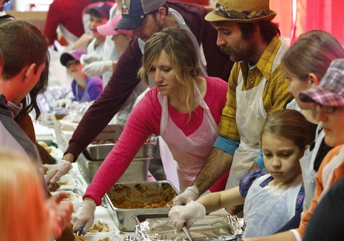 Leah Hogsten  |  The Salt Lake Tribune
Salvation Army volunteer Erin Murphy, center, spoons up sweet potatoes Thursday for the other volunteers packaging and delivering meals in Salt Lake City. On Thursday the Salvation Army prepared and delivered some 450 Thanksgiving dinners to people who are basically shut in and can't be with friends or family on the holiday.
