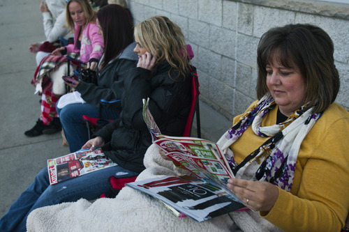 Chris Detrick  |  The Salt Lake Tribune
Debbie Goodwin, of Taylorsville, looks at ads while waiting in line for the 8pm opening of Toys"R"Us in Murray Thursday November 22, 2012.