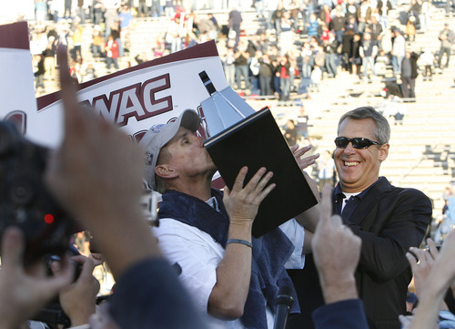 Scott Sommerdorf  |  The Salt Lake Tribune              
Utah State head coach Gary Andersen kisses the WAC trophy as Athletic Director Scott Barnes applaudes at right. Utah State defeated Idaho 45-9 in Logan, Saturday, November 24, 2012 to become champions of the WAC.