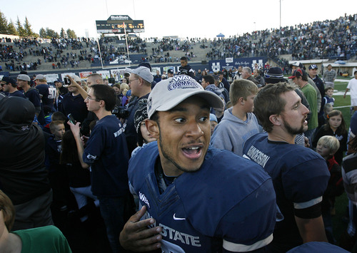 Scott Sommerdorf  |  The Salt Lake Tribune              
Utah State QB Chuckie Keeton bounds through the crowd of fans and team mates after the win over Idaho. Utah State defeated Idaho 45-9 in Logan, Saturday, November 24, 2012 to become champions of the WAC.