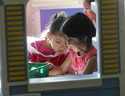 Al Hartmann  |  The Salt Lake Tribune
Preschoolers Jackeline Cortez, left, and Constanza Huancos play together in a "clubhouse" at Neighborhood House. Neighborhood House has been serving families in Salt Lake City for years, and has the state's only accredited, private, year-round nonprofit preschool.