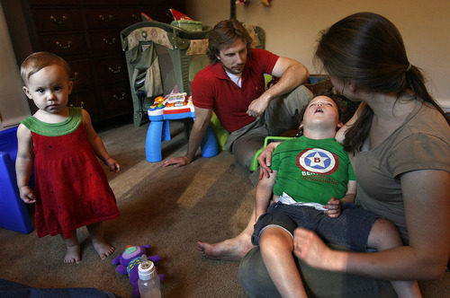 Scott Sommerdorf  |  The Salt Lake Tribune             
Bertrand Might's father, Matthew Might, watches as therapist Victoria Kochanek works with Bertrand in his home, Thursday, August 2, 2012. Bertrand's sister, Victoria, is at left.