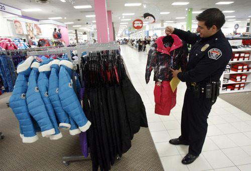 Francisco Kjolseth  |  The Salt Lake Tribune
West Valley City Police officer Franco Libertini picks out clothes for a young girl as part of the West Valley City Giving Tree at Valley Fair Mall on Tuesday, Nov. 27, 2012, benefiting 176 youth from 58 families. Those interested in supporting the program can choose and check out a name from the trees located near the Valley Fair Mall Customer Service Center; service representatives will provide a list of the child's needs and holiday wishes. Shoppers are then asked to return the unwrapped gifts to the desk before Dec. 15. The West Valley City Police Department's Community Services Section started the tradition several years ago when a family they were working with experienced multiple tragedies and were left with no resources for the holidays. The department now coordinates with a local organization that works with low-income families in the city to choose names for the tree.