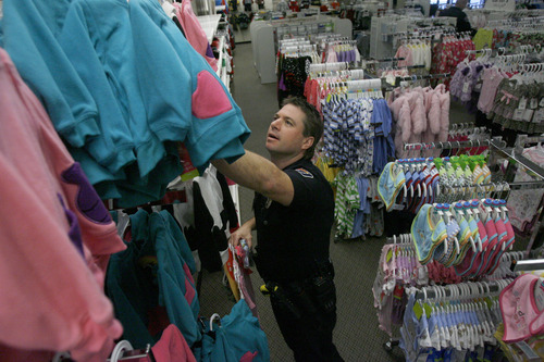 Francisco Kjolseth  |  The Salt Lake Tribune
West Valley City Police officer Devin Novara picks out clothes for a young girl as they kick off the West Valley City Giving Tree at Valley Fair Mall on Tuesday, Nov. 27, 2012, benefiting 176 youth from 58 families. Those interested in supporting the program can choose and check out a name from the trees located near the Valley Fair Mall Customer Service Center; service representatives will provide a list of the child's needs and holiday wishes. Shoppers are then asked to return the unwrapped gifts to the desk before December 15. The West Valley City Police Department's Community Services Section started the tradition several years ago when a family they were working with experienced multiple tragedies and were left with no resources for the holidays. The department now coordinates with a local organization that works with low-income families in the city to choose names for the tree.