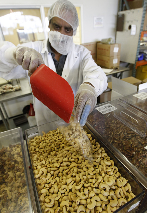 Al Hartmann  |  The Salt Lake Tribune
Sam Victor weighs and bags fresh cashews at Western Nut Factory.   Cashews are the most popular among their varieities.   Western Nut, a long-time Utah company, is preparing for the busy holiday rush.