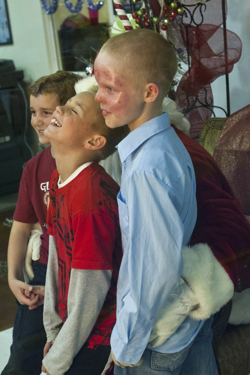 Chris Detrick  |  The Salt Lake Tribune
Burn victims Kayden Godfrey, 8, Spencer Cronin, 10, and Tyler Bergman, 10, pose for a portrait with Santa during a fundraising event for the five young victims injured by a gasoline fire in Perry on Nov. 15 at The Peak in Perry Friday November 30, 2012. The boys, ages 7-10, were injured after they began experimenting with gasoline and fire while walking home from school. The combination resulted in an explosion that sent three of the boys by helicopter to the University of Utah Burn Center. The youngest victim, Tayton Winward, suffered burns over 14 percent of his body, mainly to his arms and face, and will remain in ICU for the next several weeks. Community members who would like to donate can do so for Tayton Windward at any Zions Bank branch or online under Kali Winward account #037 386419; or for Kayden Godfrey at any America First Credit Union branch under Blake Godfrey account #9056433.