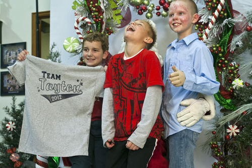Chris Detrick  |  The Salt Lake Tribune
Burn victims Kayden Godfrey, 8, Spencer Cronin, 10, and Tyler Bergman, 10, pose for a portrait with Santa during a fundraising event for the five young victims injured by a gasoline fire in Perry on Nov. 15 at The Peak in Perry Friday November 30, 2012. The boys, ages 7-10, were injured after they began experimenting with gasoline and fire while walking home from school. The combination resulted in an explosion that sent three of the boys by helicopter to the University of Utah Burn Center. The youngest victim, Tayton Winward, suffered burns over 14 percent of his body, mainly to his arms and face, and will remain in ICU for the next several weeks. Community members who would like to donate can do so for Tayton Windward at any Zions Bank branch or online under Kali Winward account #037 386419; or for Kayden Godfrey at any America First Credit Union branch under Blake Godfrey account #9056433.