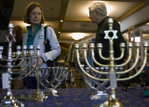 Kim Raff  |  The Salt Lake Tribune
Karen McArthur walks by a display of menorahs for sale at the Hanukkah Market at the Jewish Community Center in Salt Lake City on December 2, 2012.