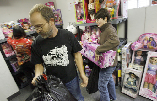 Francisco Kjolseth  |  The Salt Lake Tribune
Toni Webb and Don Roberts, from left, pick out toys for their 6-year-old daughter as their case manager at The Road Home, Melissa Kelly, helps them carry their belongings on Tuesday, December 4, 2012. Representatives from the YWCA, The Road Home, and Volunteers of America, Utah, began the 18th annual Candy Cane Corner holiday store, where low-income parents select new clothes and toys for their children along with necessities for themselves in Salt Lake City.