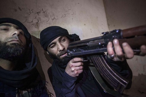 In this Wednesday, Dec. 5, 2012 photo, a Free Syrian Army fighter aims his weapon during heavy clashes with government forces in Aleppo, Syria. (AP Photo/Narciso Contreras)
