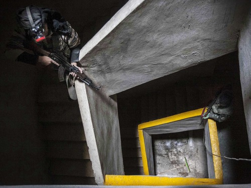 In this Wednesday, Dec. 5, 2012 photo, Free Syrian Army fighters aim their weapons inside an abandoned building during heavy clashes with government forces in Aleppo, Syria. (AP Photo/Narciso Contreras)