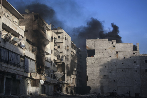 In this Wednesday, Dec. 5, 2012 photo, smoke rises from residential buildings due heavy fighting between Free Syrian Army fighters and government forces in Aleppo, Syria. (AP Photo/Narciso Contreras)