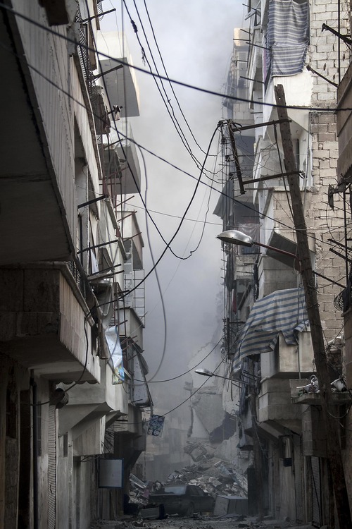 In this Wednesday, Dec. 5, 2012 photo, smoke rises from residential buildings due heavy fighting between Free Syrian Army fighters and government forces in Aleppo, Syria. (AP Photo/Narciso Contreras)