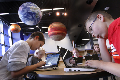 Scott Sommerdorf  |  The Salt Lake Tribune              
Third-graders in Danna Fergusen's class; John Ketzouradis, left, Jaydie Shields, Sarah Burgon, Shaylee Ford and Jake Wilkins, right, work on their laptops beneath huge representations of the solar system at Endeavour Elementary's library on Friday. Utah recently released new accountability data for all Utah public schools, and Endeavour Elementary has the third-highest score in the state under the system.