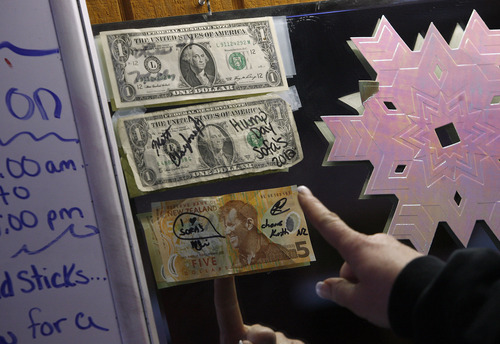Scott Sommerdorf  |  The Salt Lake Tribune              
Bartender Jamielyn Vanderhoof points out the bar's first dollar bill when the bar opened as Sofa's in 2009. Sofa's Bar in Garland, Utah, began selling beer on Sunday and will continue to sell on Sundays through Super Bowl Sunday on Feb. 13.