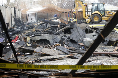 Al Hartmann  |  The Salt Lake Tribune
West Valley City Fire Department investigators sift through debris of 10 cars that burned in a carport at apartment complex at 3685 S. 2200 West on Dec. 11.  The fire started about 12:30 a.m.