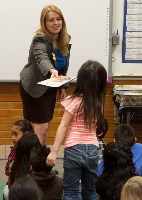 Trent Nelson  |  The Salt Lake Tribune
Jen Tomchak of the Salt Lake City law firm of Parr Brown Gee & Loveless hands out books to children at Stansbury Elementary on Tuesday, Dec. 11, 2012 in West Valley City as part of the Utah State Bar's "Books from Barristers" program.