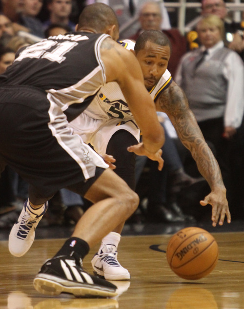 Rick Egan  | The Salt Lake Tribune 

Utah Jazz point guard Mo Williams (5) picks up a loose ball, as San Antonio Spurs power forward Tim Duncan (21) defends, in NBA action, at the Energy Solutions Arena, Wednesday, December 12, 2012.