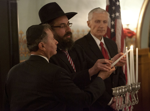Steve Griffin | The Salt Lake Tribune
Rabbi Benny Zippel, flanked by John Price, left, and Utah Lt. Gov. Greg Bell, helps Price light a menorah during lighting ceremony at the Governor's Mansion in Salt Lake City, Utah Tuesday December 11, 2012. The Hanukkah celebration was attended by dignitaries, local families and community leaders. Zippel emphasized the importance of the state celebrating the constitutional "freedom of religion," not a "freedom from religion."