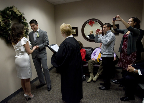 Kim Raff  |  The Salt Lake Tribune
As family and friends take pictures (left) Edna Garcia and J.C. Martinez get married by Deputy Clerk Darlene Von Bank at the Salt Lake County Clerk office in Salt Lake City on December 12, 2012. "Nobody will ever forget this date. We wanted to get married before the end of the world. It's kind of a fun thing," says Garcia of the 12/12/12 date.