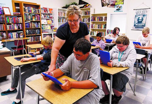 Trent Nelson  |  The Salt Lake Tribune
Dixon Middle School teacher Leann Moody helps Jacen Hansen with an iPad during a reading class in Provo on Sept. 25, 2012.