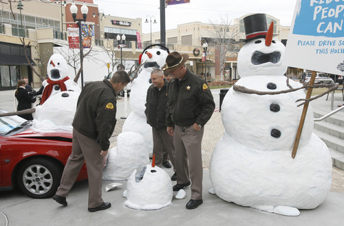 Rick Egan  |  The Salt Lake Tribune 
Utah Highway Patrol troopers check out the display at The Gateway, Thursday, Dec. 13, 2012. The splattered snowman is a graphic reminder that being hit by a drunken driver can have far-reaching consequences for humans. The display is part of the "Drive sober or get pulled over" campaign.