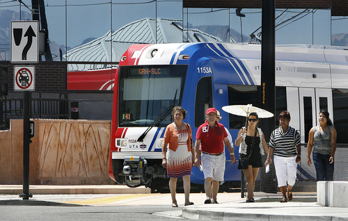 Scott Sommerdorf  |  Tribune file photo
A family on its way to shop across the street at the Valley Fair Mall, passes by a TRAX train as it leaves the West Valley Central Station in August 2011. Ridership numbers on that line have thus far risen to only 80 percent of UTA's projections.