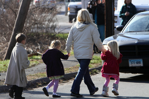 Parents walk away from the Sandy Hook Elementary School with their children following a shooting at the school, Friday, Dec. 14, 2012 in Newtown, Conn. A man opened fire inside the Connecticut elementary school where his mother worked Friday, killing 26 people, including 18 children, and forcing students to cower in classrooms and then flee with the help of teachers and police. (AP Photo/The Journal News, Frank Becerra Jr.)